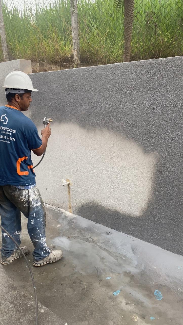 Profissional da LEO executando pintura mecanizada de uma parede externa